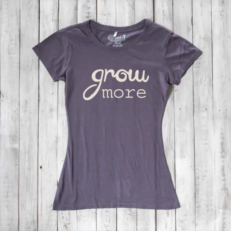 Dark purple women's T-shirt with cream 'Grow More' text. Nature-inspired bamboo and organic cotton top for gardening enthusiasts.