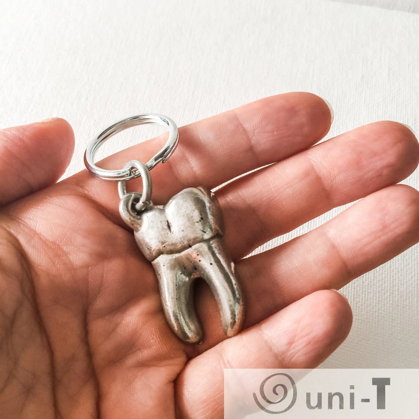 Human Tooth Keychain - Anatomical Human Molar Keychain shown in hand for scale, handcrafted pewter dental gift for dentists or collectors.