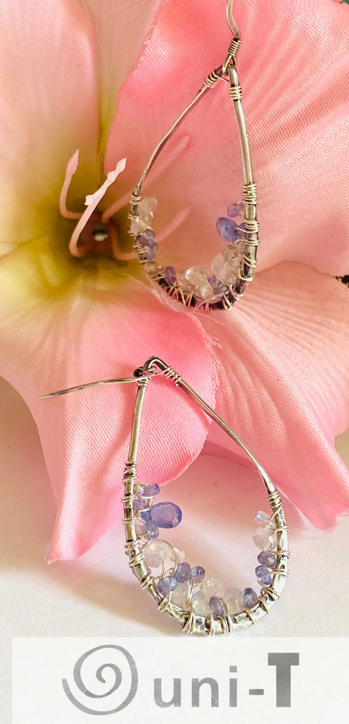Teardrop Iolite and Moonstone Earrings with sterling silver wire wrap. Handmade gemstone earrings displayed with pink flower.