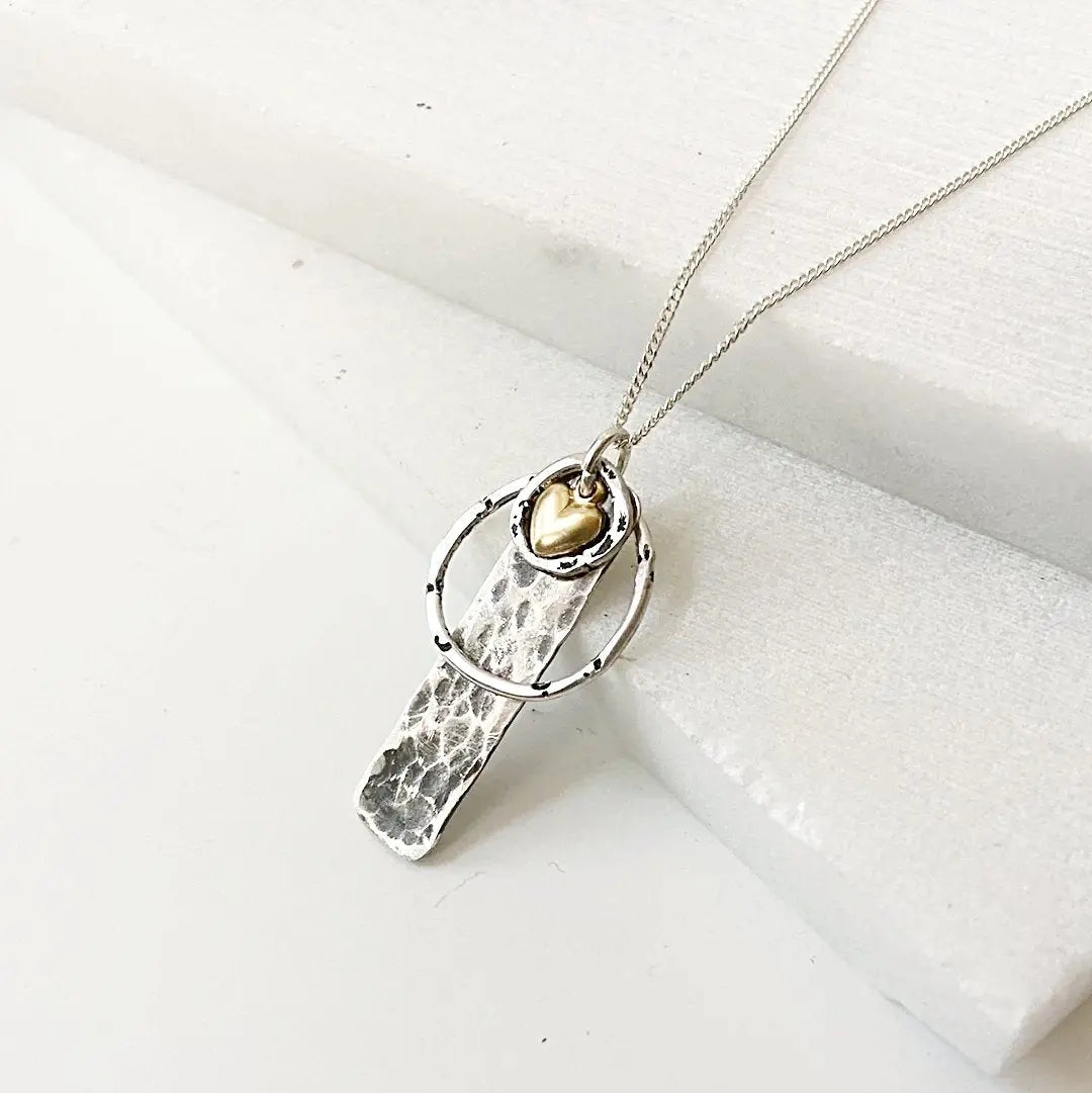 Circle Tag Necklace - Silver Circle Gold Heart | Sterling features a hammered silver tag with a gold heart charm on a sterling silver chain. Elegant and modern accessory.