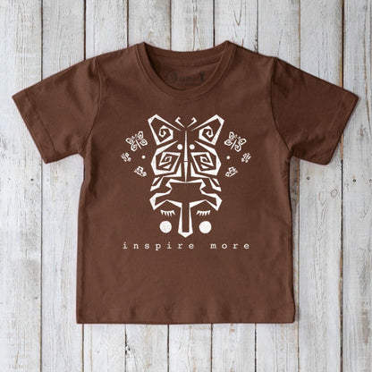 Brown kids' organic cotton t-shirt featuring white tribal butterfly and 'Inspire More' text. Sustainable Uni-T graphic tee with positive message.