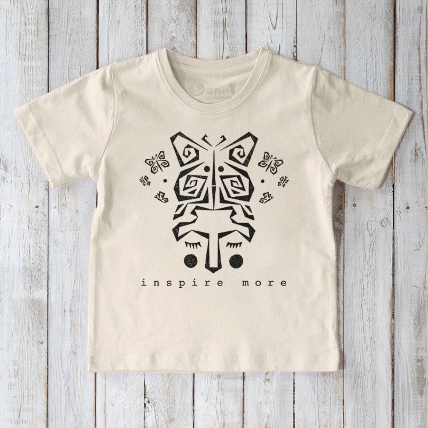 Cream kids' organic cotton t-shirt with black butterfly graphic and 'Inspire More' text. Eco-friendly Uni-T nature-inspired sustainable top.