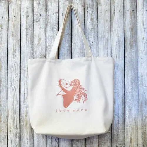 Organic Canvas Tote Bag - Anniversary Gift with 'LOVE MORE' artist design in pink ink. Eco-friendly and perfect for sustainable fashion lovers.