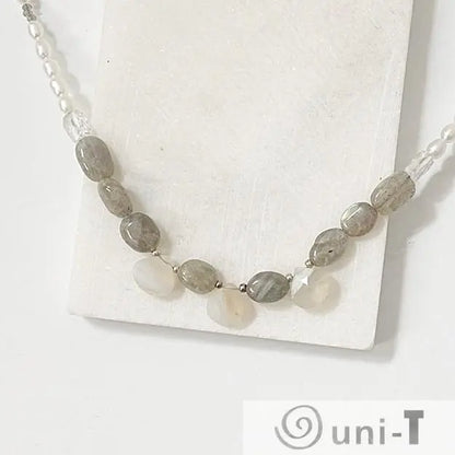 Close-up of labradorite pearl necklace showcasing polished gemstone arrangement and sterling silver clasp on white background.