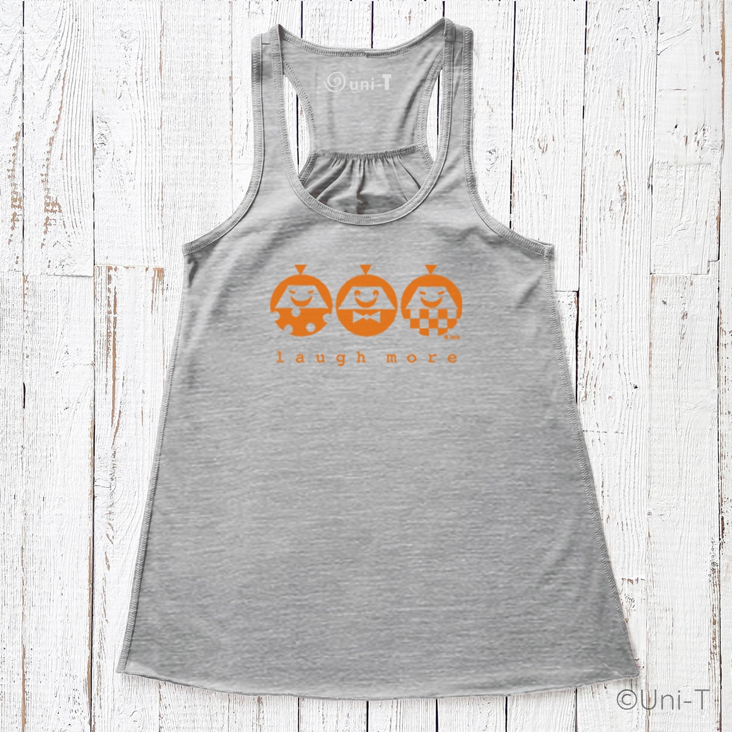 Heather gray women's flowy tank top with orange 'Laugh More' print. Comfortable and stylish for spreading positivity in everyday outfits.