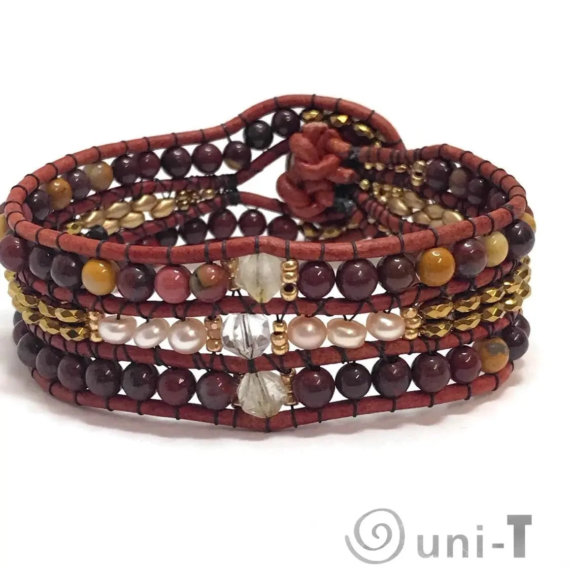 Back view of multi gemstone cuff bracelet with pearl, quartz, and leather detailing, secured by a floral loop closure.