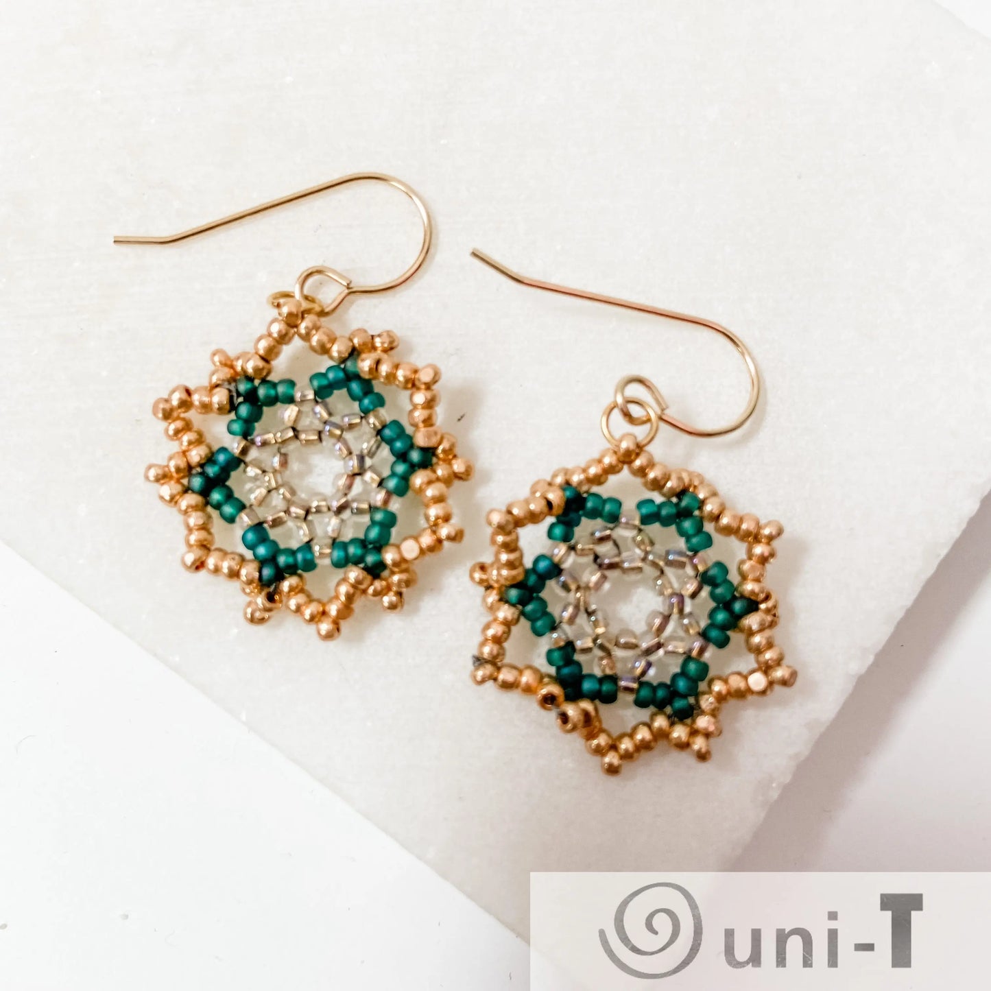 Green Medallion Earrings with forest-colored beads and sterling silver French ear wires, arranged in a floral pattern for a unique accessory.