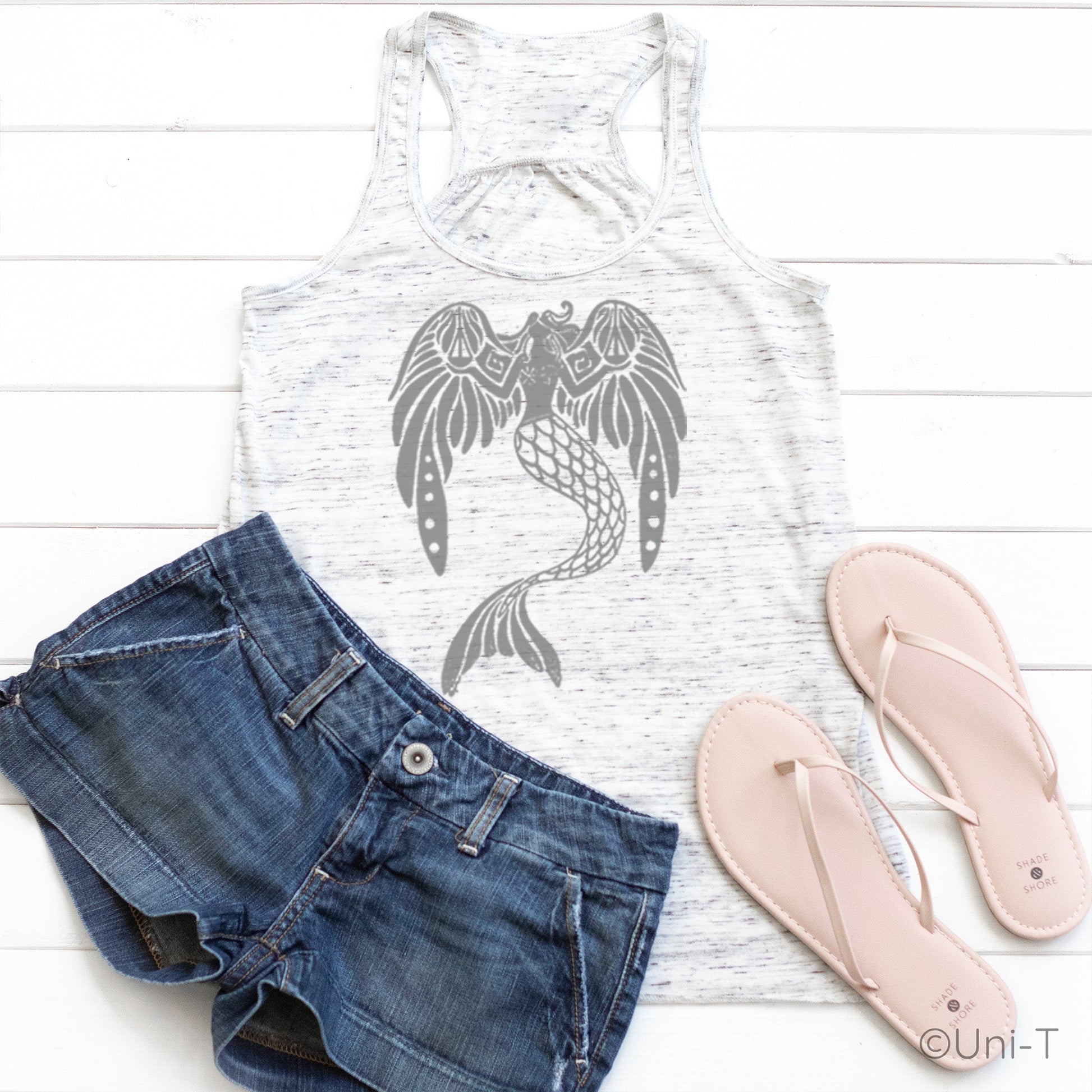White speckled flowy tank top for women with grey mermaid design, styled with denim shorts and sandals. Lightweight and eco-conscious fabric.