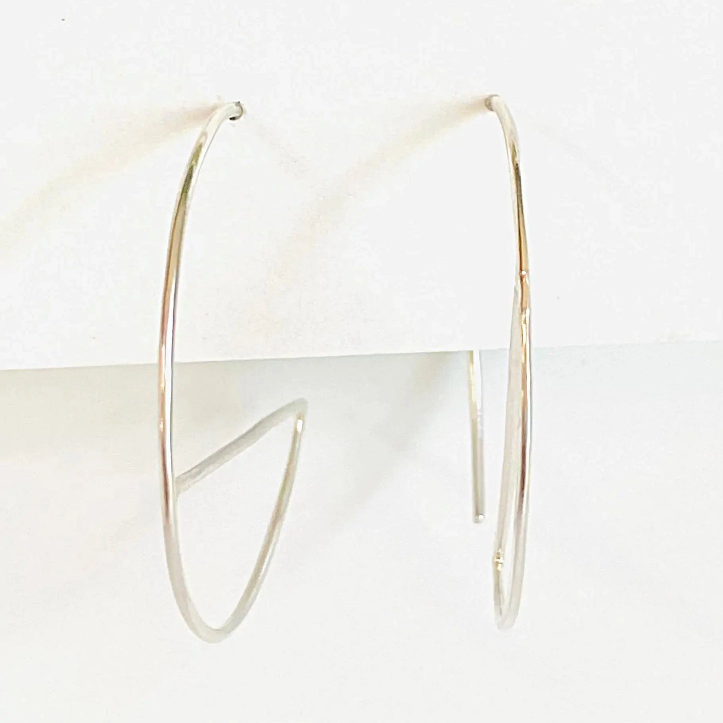 Side view of modern sterling silver hoop earrings with open circle and bar detail. Lightweight 1” diameter hoops in minimalist style.