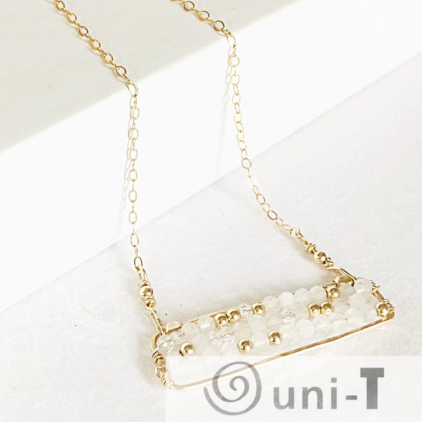 Detailed shot of Moonstone Bar Necklace showing gold-filled wire wrapping and 2 mm moonstone beads. A delicate and stylish necklace design.