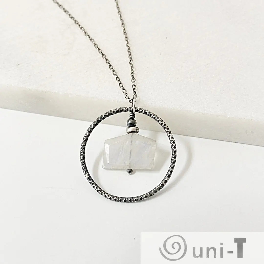Sterling Silver Moonstone Necklace with geometric moonstone wrapped in center of textured circle, elegant infinity jewelry piece.