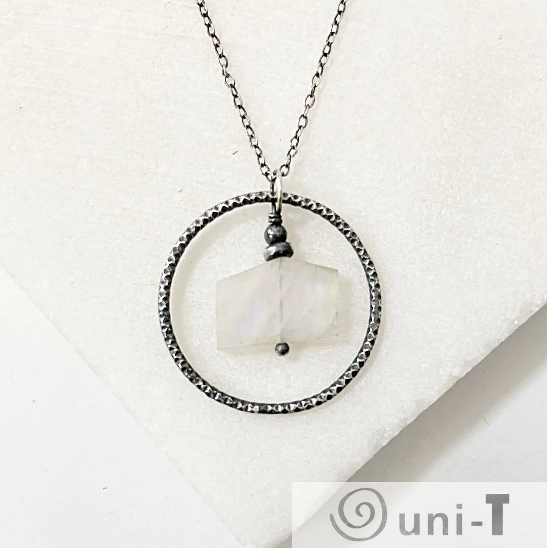 Infinity Necklace with moonstone pendant in hammered silver circle, handcrafted for a unique jewelry accessory look.