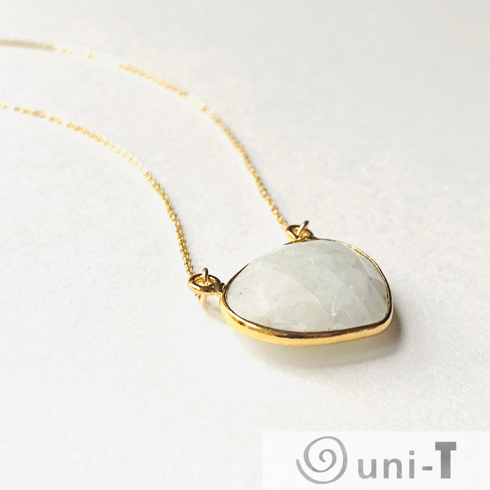 Angled view of moonstone necklace with gold filled setting and chain. The faceted gemstone adds a subtle shimmer to the design.