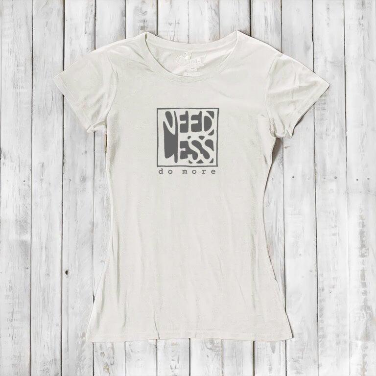 Ivory white women's bamboo and organic cotton t-shirt with 'Need Less Do More' quote. Minimalist and eco-conscious fashion top.
