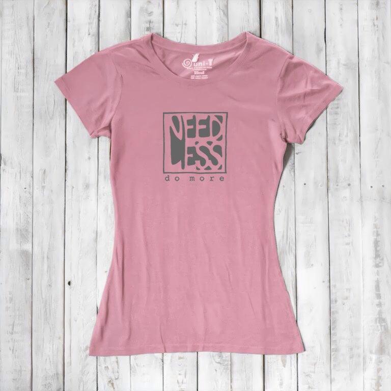 Soft pink women's motivational t-shirt in bamboo and organic cotton. 'Need Less Do More' quote tee for sustainable minimalist style.