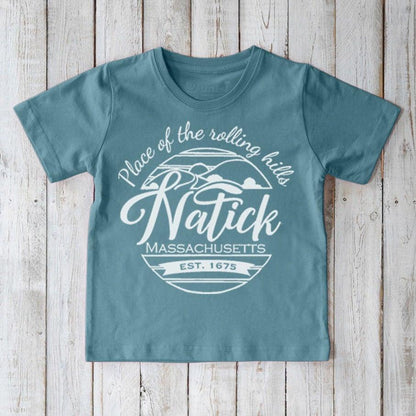 Kids' Natick Organic Cotton T-Shirt in blue with 'Place of the rolling hills' graphic. Eco-friendly local pride tee by Uni-T for children.