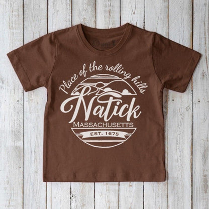 Brown Kids' Natick Organic Cotton T-Shirt with white 'Place of the rolling hills' print. Eco-friendly local pride tee for kids.