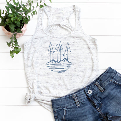 White speckled Nature Flowy Tank Top for Women styled with denim shorts. Features blue mountain and tree design for outdoor lifestyle.