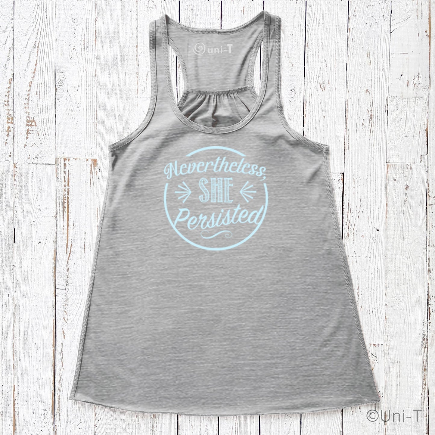Gray racerback tank top with light blue 'Nevertheless She Persisted' print. Eco-friendly ink on strength apparel for women.