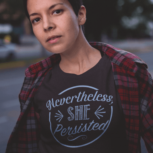 Model wearing 'Nevertheless She Persisted' bamboo and organic cotton t-shirt in dark gray. Sustainable feminist statement apparel by Uni-T.
