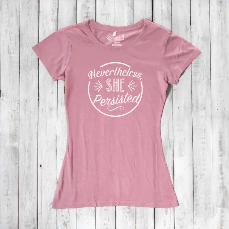 Light pink 'Nevertheless She Persisted' tee for women with white text. Organic cotton and bamboo blend top promoting equality and resilience.