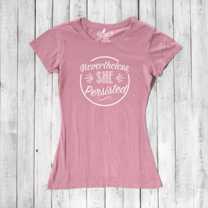 Light pink 'Nevertheless She Persisted' tee for women with white text. Organic cotton and bamboo blend top promoting equality and resilience.