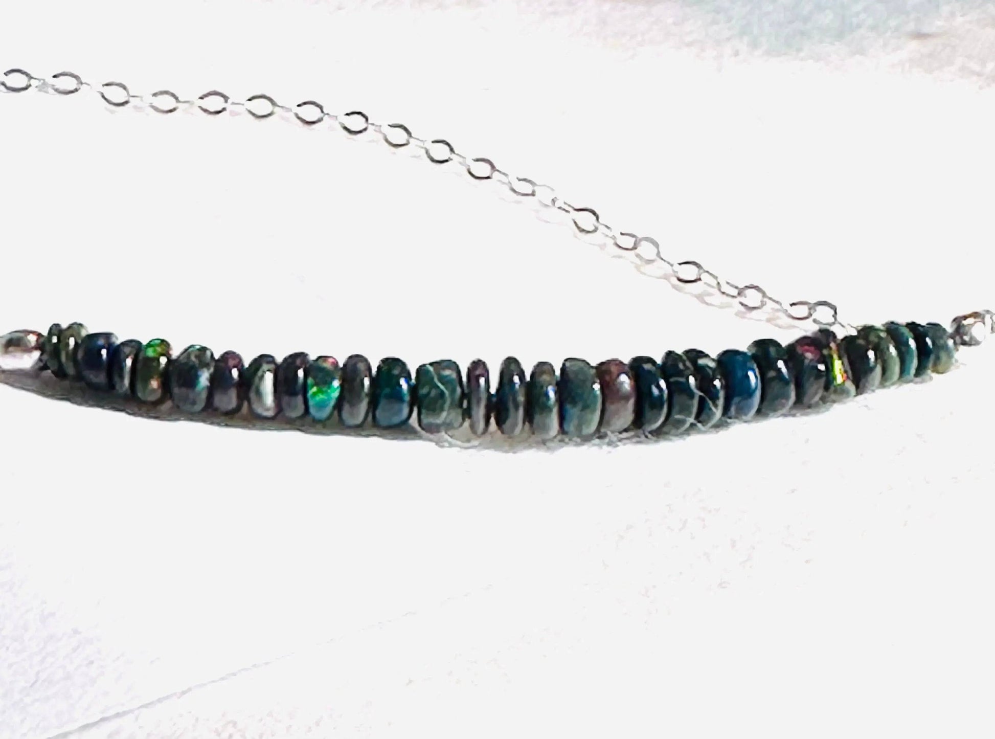 Close-up of Opal Bar Necklace showing vibrant multicolor opal beads strung on a sterling silver chain.
