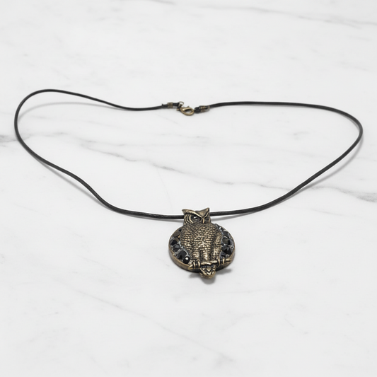 Vintage brass owl pendant necklace with black crystal accents and adjustable leather cord, perfect for animal totem jewelry collections.