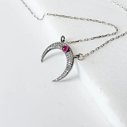 Sterling silver moonstone ruby necklace with crescent moon design, featuring pave set moonstone and ruby on a 16'' antique chain.