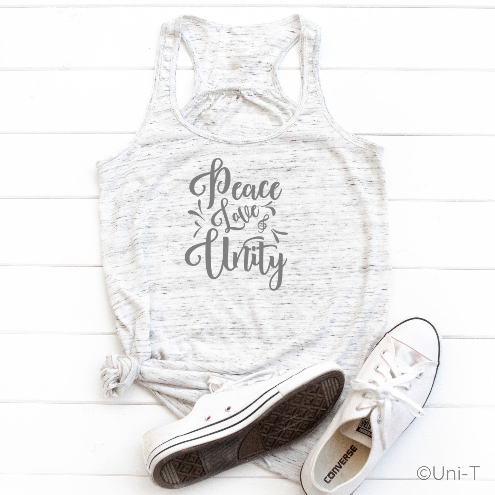 "Peace Love Unity" Tank Top - Embrace Harmony in a light heathered white racerback style, styled with white Converse shoes on a white wood background.