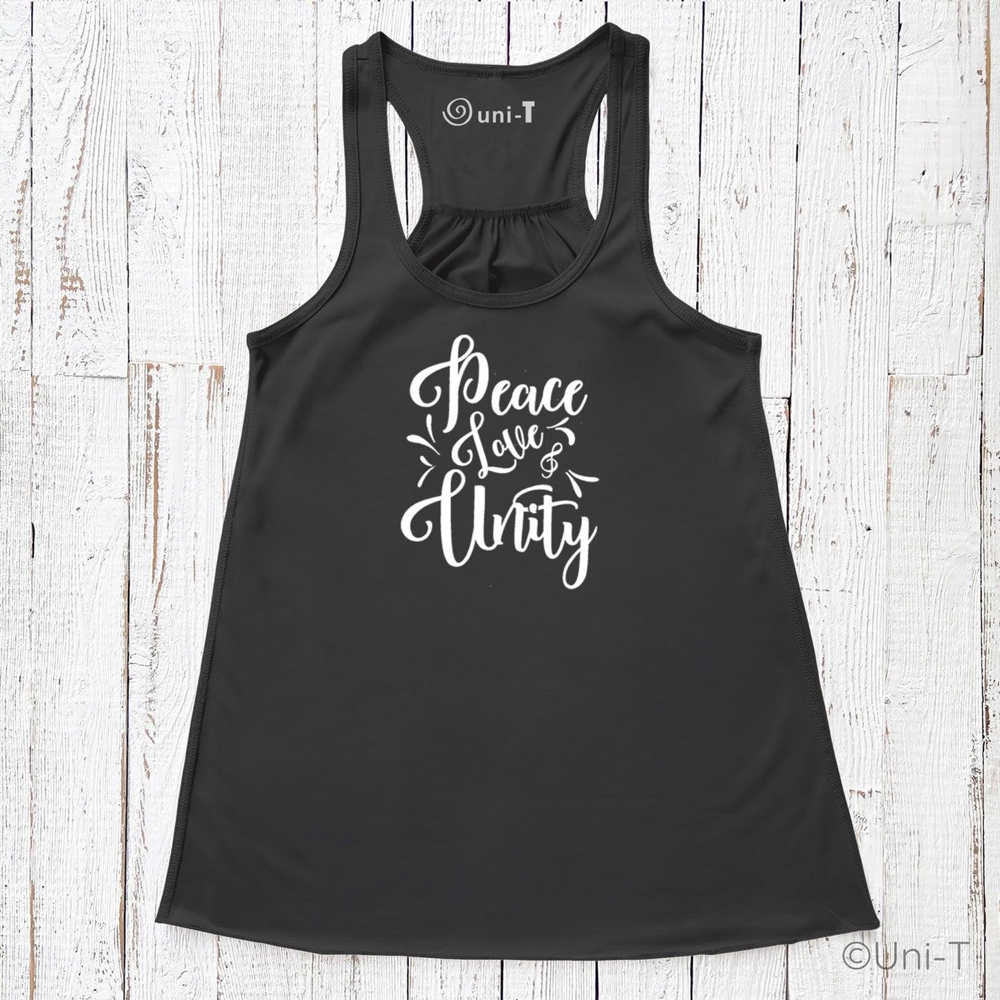 Black "Peace Love Unity" Tank Top - Embrace Harmony with white script text, laid flat on a rustic white wooden surface.