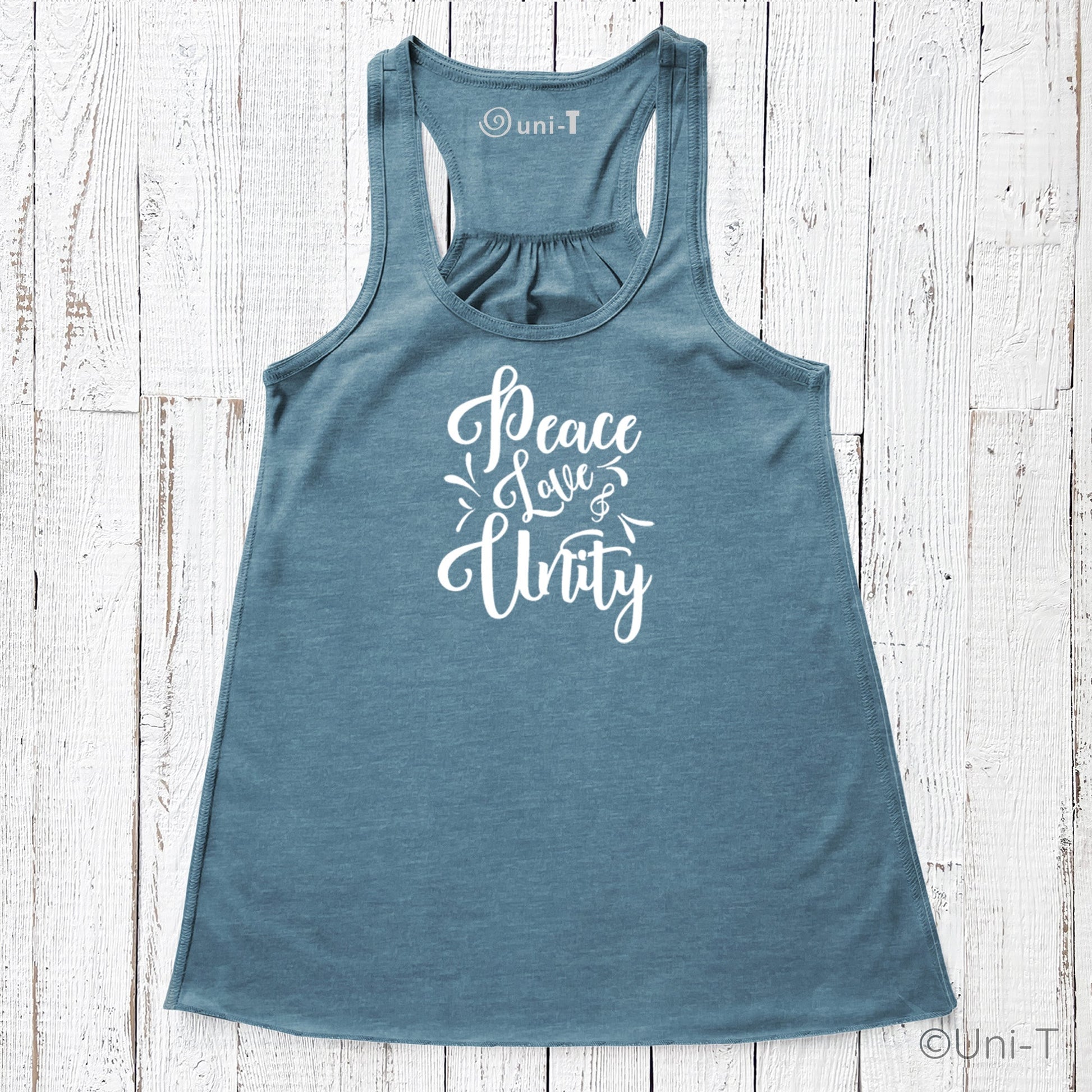 Blue "Peace Love Unity" Tank Top - Embrace Harmony featuring white lettering, displayed flat on a white wood background.