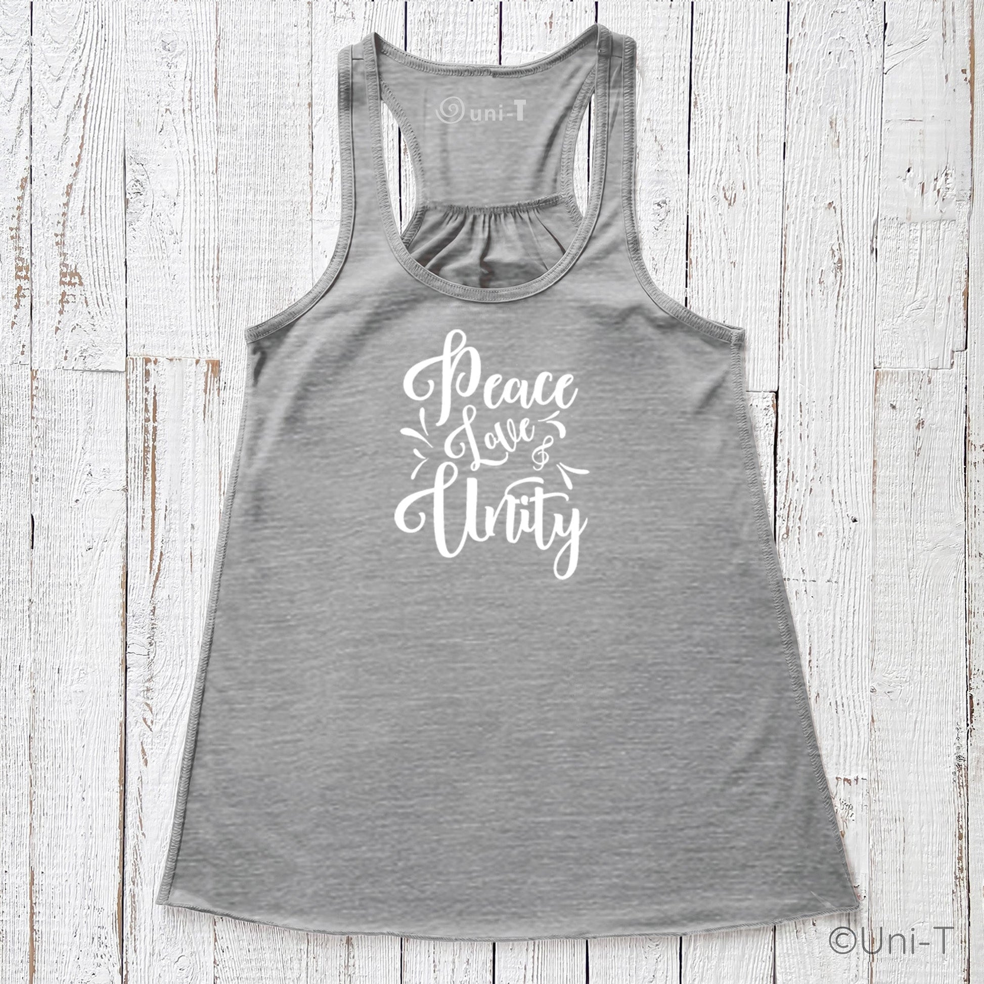 Gray "Peace Love Unity" Tank Top - Embrace Harmony with white print, racerback cut, laid flat on a textured white wood surface.