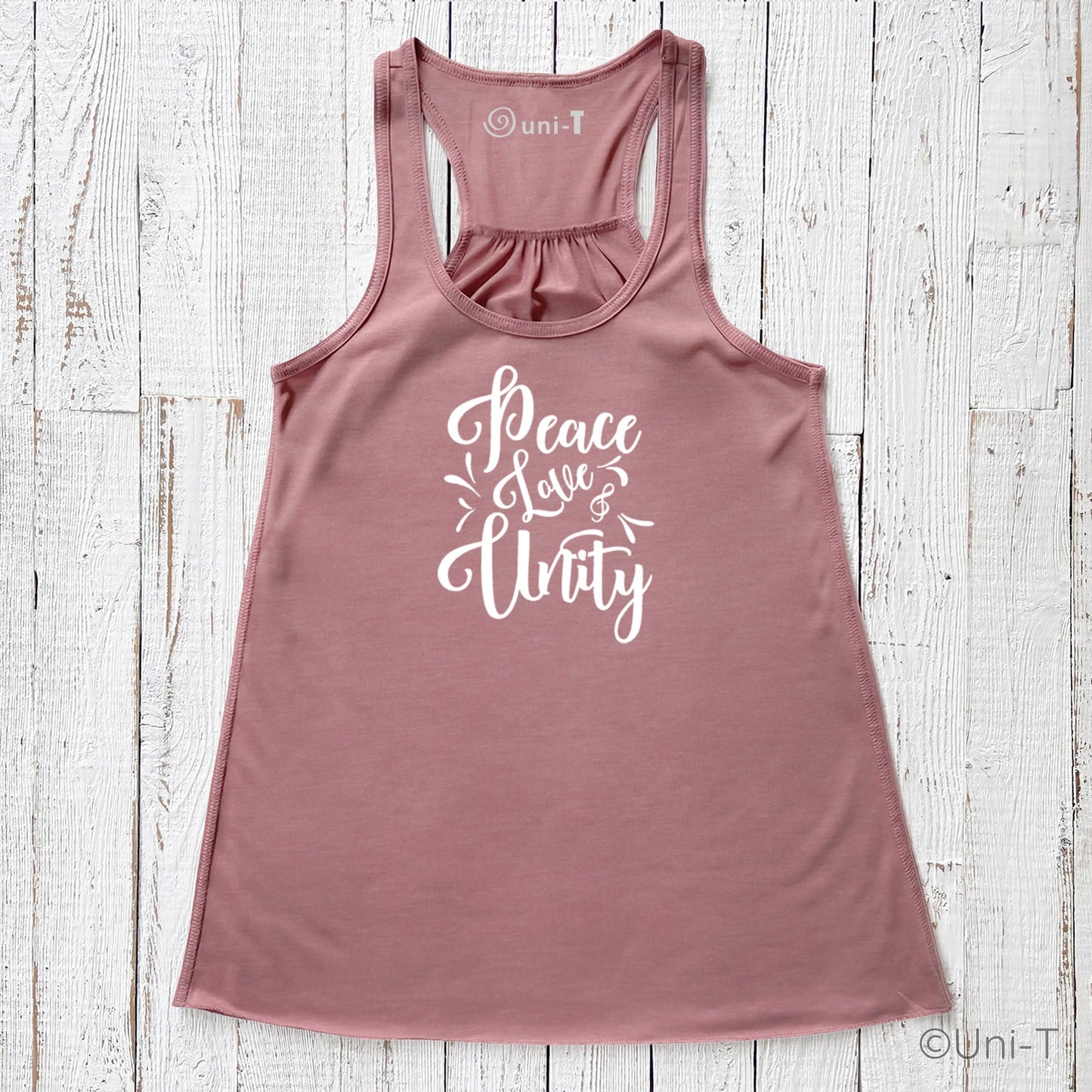 Mauve "Peace Love Unity" Tank Top - Embrace Harmony in soft fabric with white script, shown flat on a white wooden background.