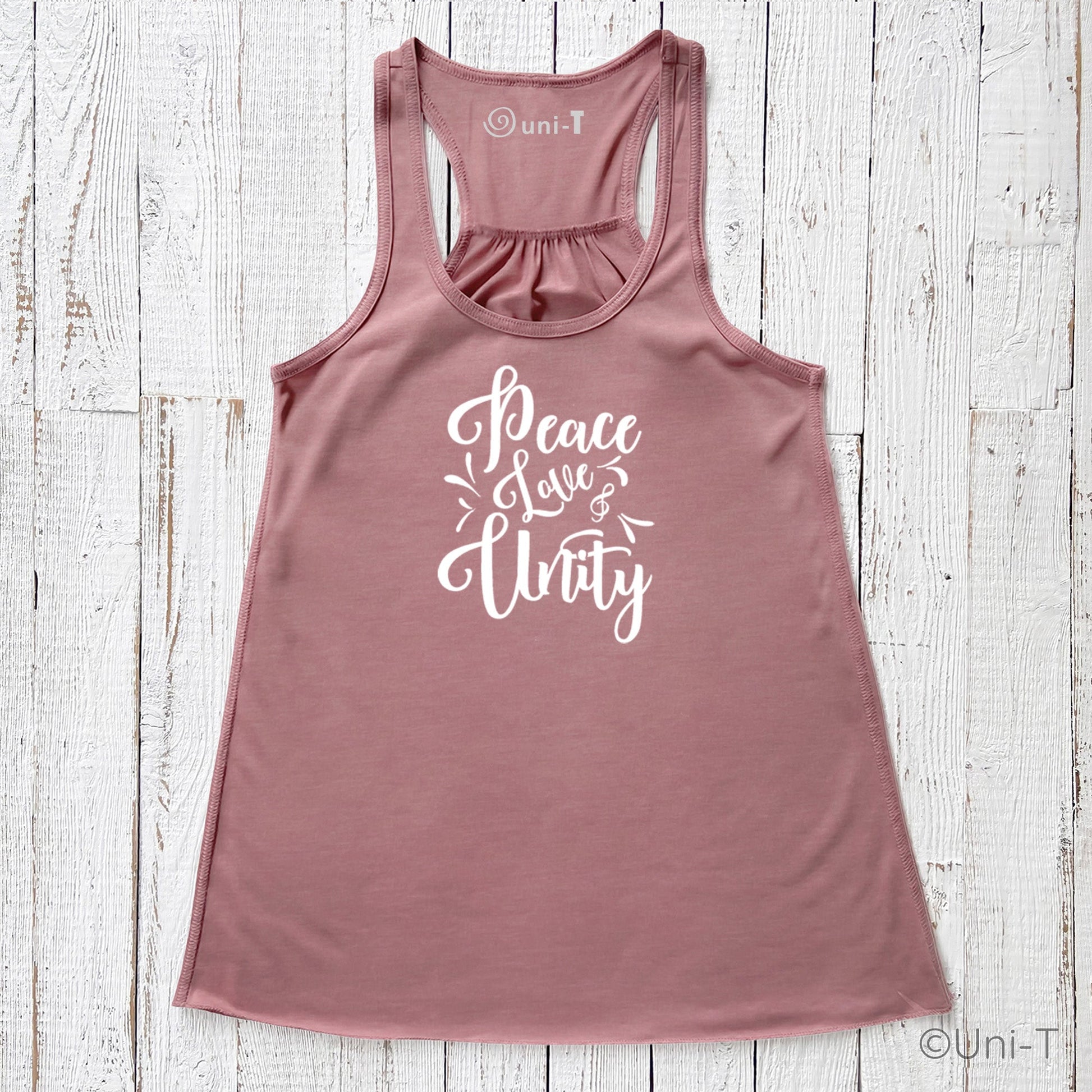 Mauve "Peace Love Unity" Tank Top - Embrace Harmony in soft fabric with white script, shown flat on a white wooden background.