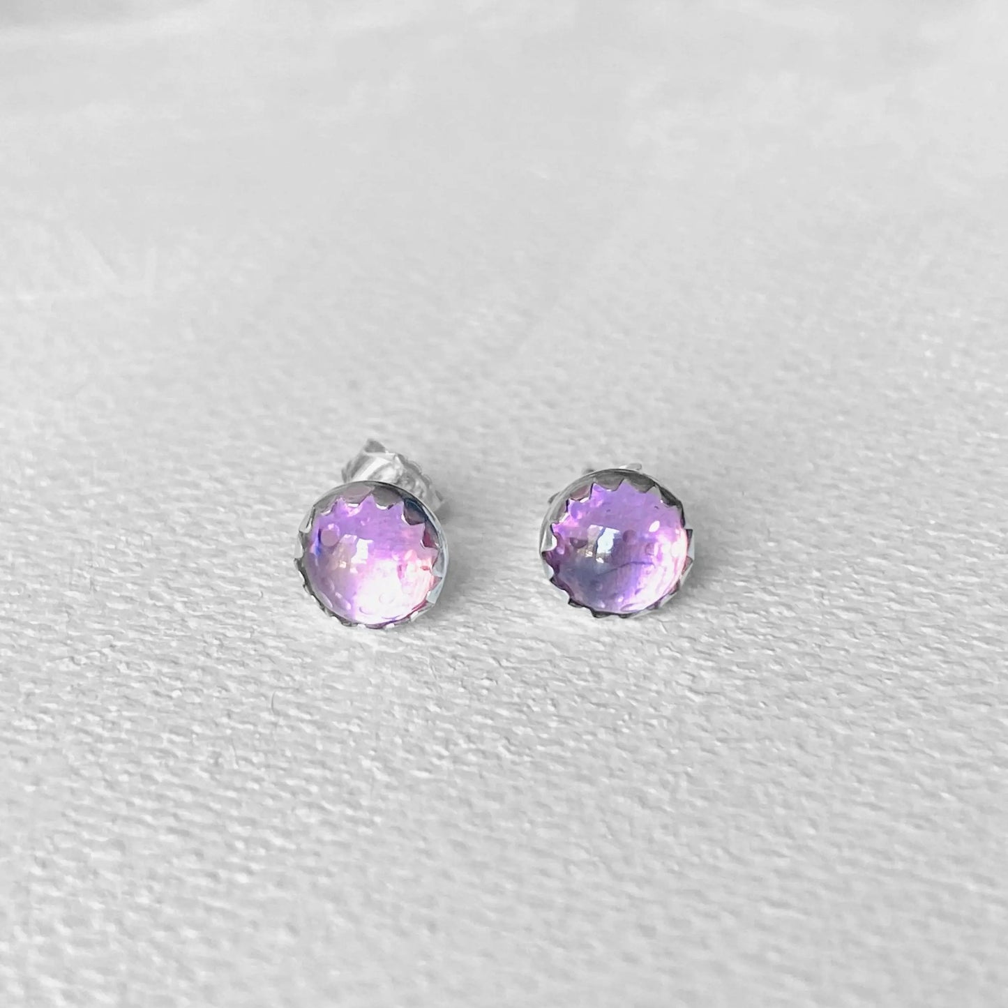 Pink CZ earrings featuring 6mm round-cut stones in sterling silver settings. Sparkling pink studs perfect for casual or formal looks.