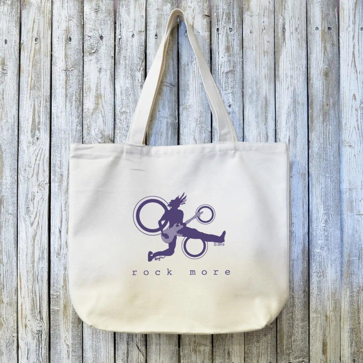 Guitar Art Organic Canvas Tote with Rock More design in purple ink, featuring a jumping guitarist silhouette on eco-friendly cotton canvas.