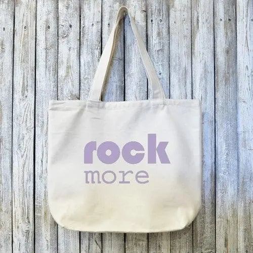Organic canvas tote bag with 'rock more' text in bold lavender font, ideal gift for rock music lovers and eco-conscious shoppers.