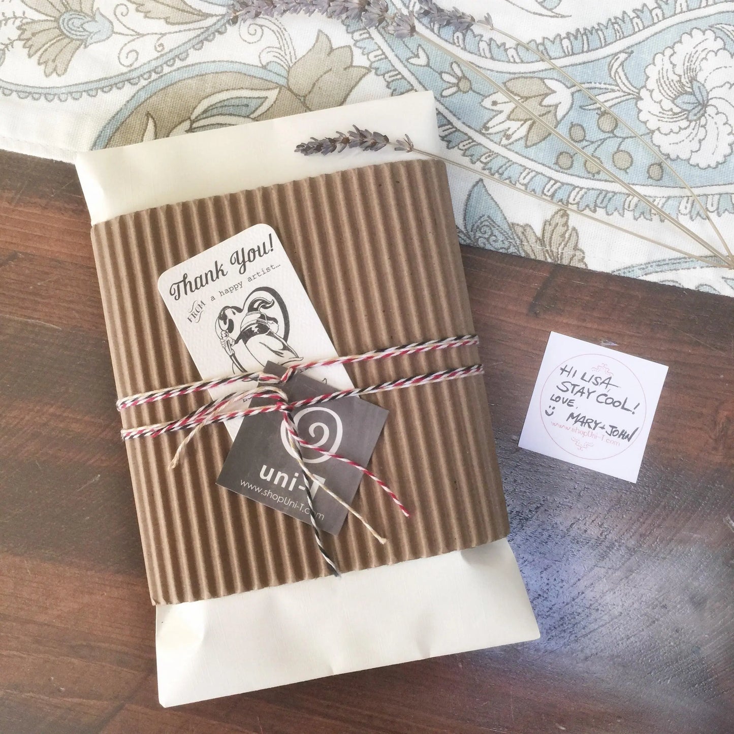 Eco-friendly gift packaging for organic canvas tote bag, wrapped in kraft paper with twine and artist-designed thank you card.