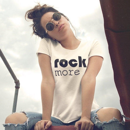 Model wearing white 'Rock More' women's bamboo & organic cotton t-shirt styled with ripped jeans. Sustainable music-themed tee for concerts.