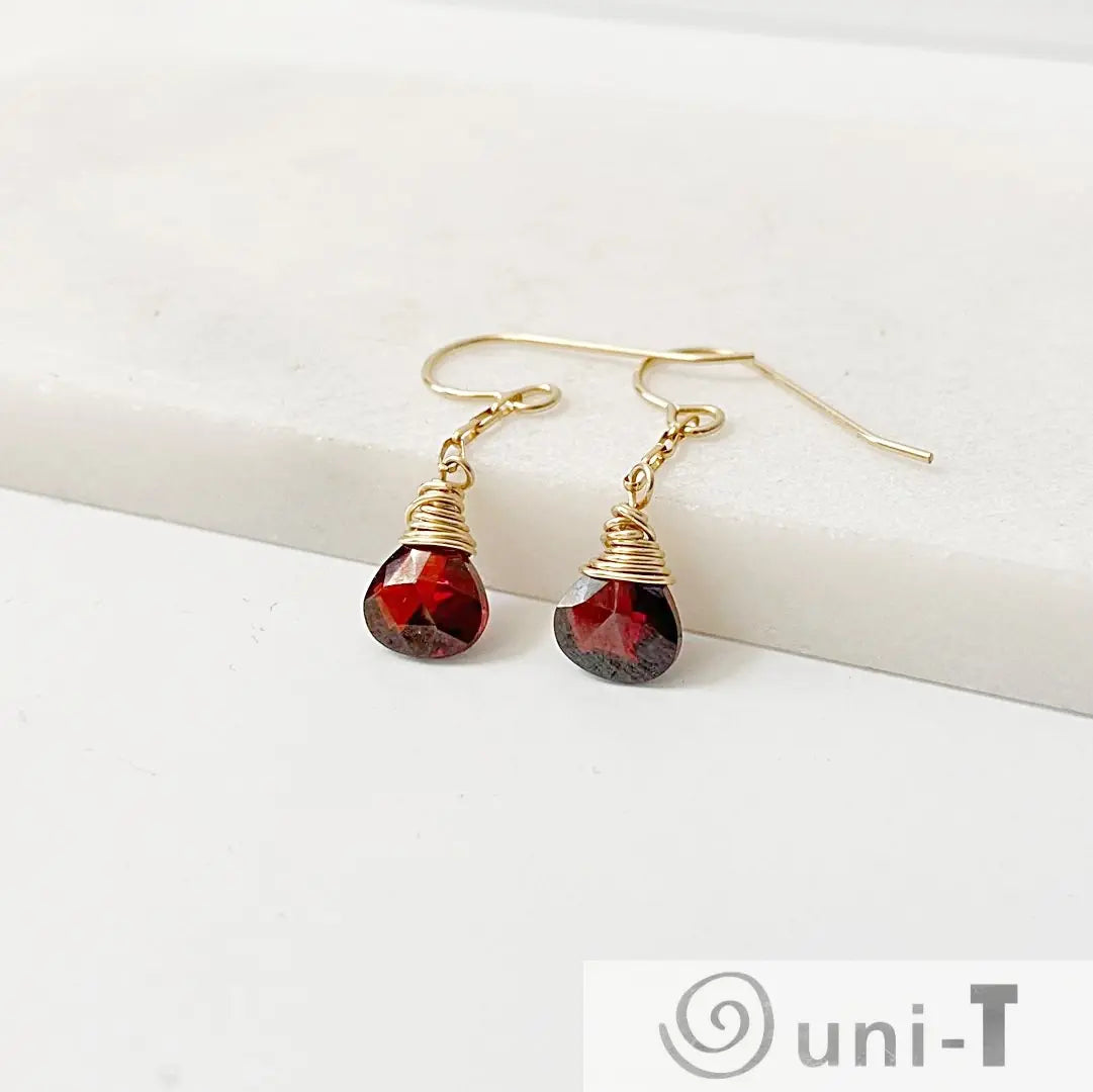 Pair of red CZ teardrop earrings with gold-filled wire wrap, displayed on white surface. 1 inch long, perfect for gifting or daily wear.