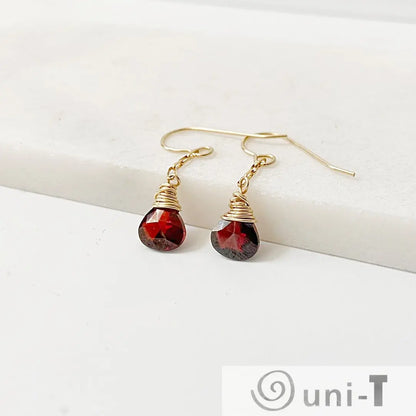 Pair of red CZ teardrop earrings with gold-filled wire wrap, displayed on white surface. 1 inch long, perfect for gifting or daily wear.