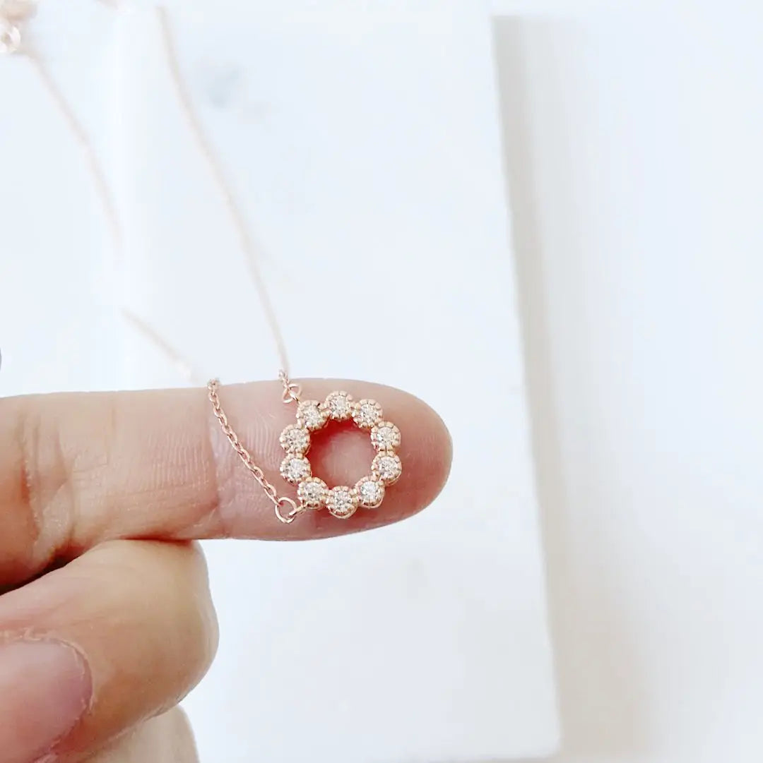 Close-up of Rose Gold Circle Necklace with cubic zirconia charm shown on fingertip, highlighting fine detail and dainty 18in silver chain design.
