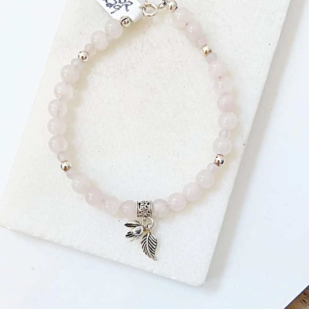Delicate Rose Quartz Silver Flower Bracelet with sterling silver clasp and charms, perfect for adding elegance to any outfit or occasion.