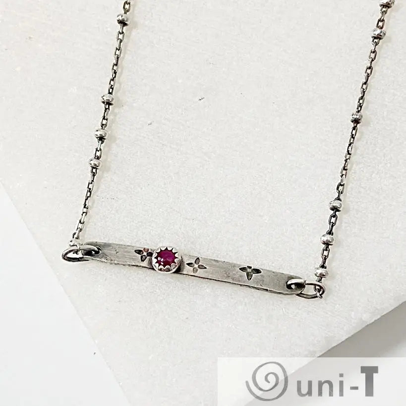 Ruby Silver Bar Necklace with 3mm Ruby Zoisite set in a flower-stamped bar on a 17-inch satellite chain. Modern gemstone necklace for women.
