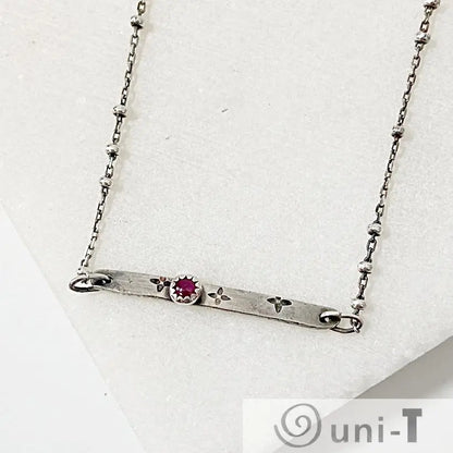 Ruby Silver Bar Necklace with 3mm Ruby Zoisite set in a flower-stamped bar on a 17-inch satellite chain. Modern gemstone necklace for women.