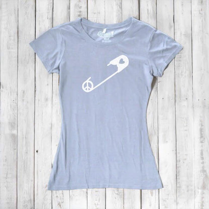 Light blue Women's Peace & Love T-Shirt with white safety pin graphic, laid flat. Eco-conscious tee promoting unity and acceptance.