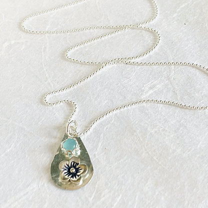 Full view of silver flower necklace with chalcedony teardrop pendant on a beaded chain. Elegant and minimalistic jewelry piece.