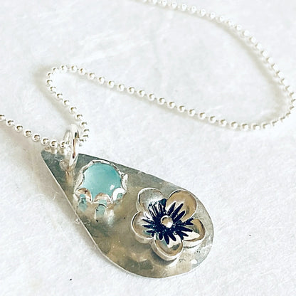Detailed view of silver teardrop pendant with chalcedony and flower design. Handcrafted necklace with sterling silver and gemstone charm.