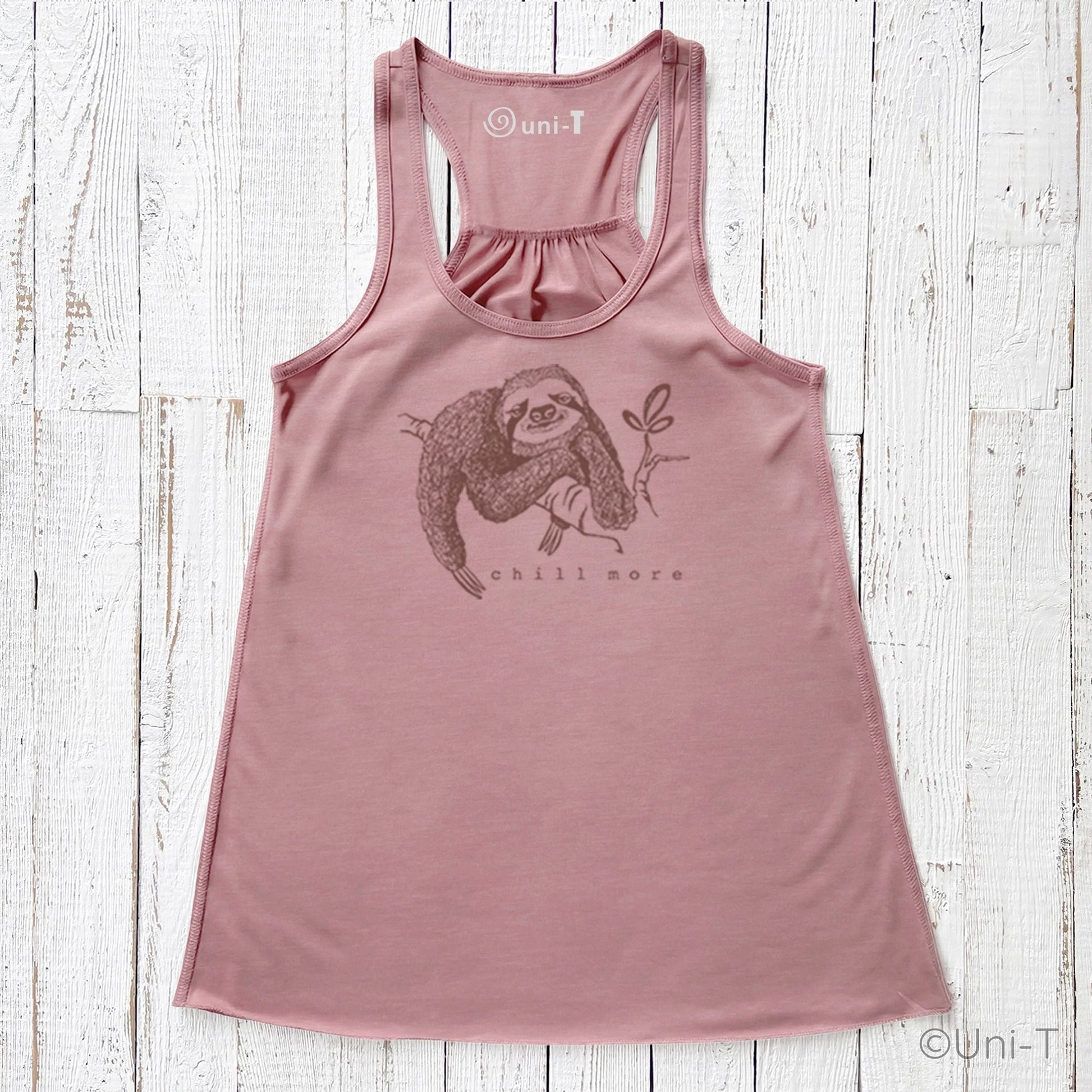 "Chill More" Women's Flowy Tank Top in mauve with sloth graphic, eco-friendly racerback design for mindful living and relaxed style.